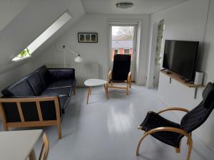 a living room with a couch and a tv at Villa Thurø Homestay in Svendborg