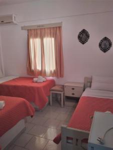 a room with two beds and a window at Psiloritis Elena in Kalamaki