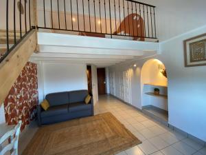 ein Wohnzimmer mit einem Sofa unter einer Treppe in der Unterkunft Auberge de la Tour de Brison in Sanilhac