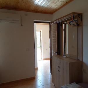 ein Bad mit einem Spiegel und einer Kommode im Zimmer in der Unterkunft Mustafaraj Apartments Ksamil in Ksamil