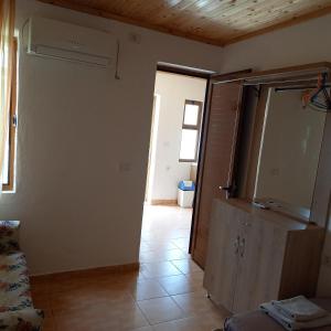 uma sala de estar com um armário e piso em azulejo em Mustafaraj Apartments Ksamil em Ksamil