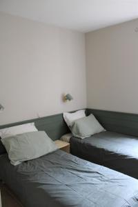 a bedroom with two beds and a night stand with a bedskirts at Bastidon avec piscine Gordes Lubéron in Gordes +11 photos