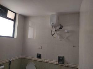 1BHK AC Service Apartment 115 في بيون: حمام مع مرحاض وكاميرا على الحائط