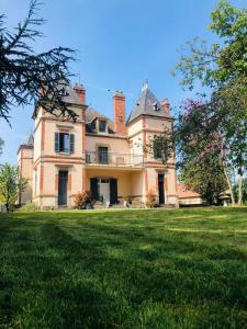 a large house with a grass field in front of it at Château Ségot in Neuilly-le-Réal