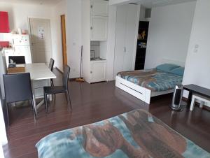 1 dormitorio con cama, escritorio y mesa en Studio indépendant 40m² avec jardin privé, en Hauteville-Lompnes