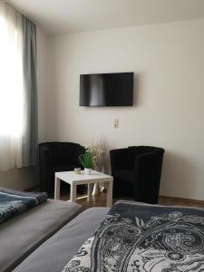 1 dormitorio con 2 camas y TV en la pared en Havelberg Ferien Apartments HCR, en Havelberg