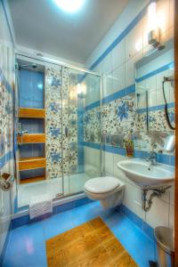 a blue and white bathroom with a sink and a shower at Hotel Carpatia Bieszczadzki Gościniec in Wetlina