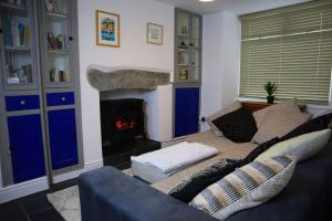 a living room with a couch and a fireplace at Dol Bach - Your homely Welsh Cottage in the Heart of Snowdonia in Blaenau-Ffestiniog