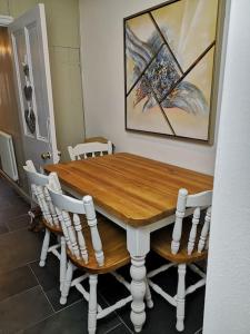 a wooden table and chairs in a room at Dol Bach - Your homely Welsh Cottage in the Heart of Snowdonia in Blaenau-Ffestiniog