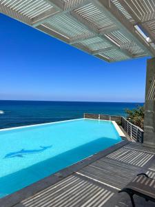 una piscina con vista sull'oceano di Beach Villa Pantheon a Pomos