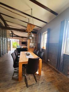 a dining room with a wooden table and black chairs at Alten Bahnhof Oberdorla/ Thüringen in Niederdorla