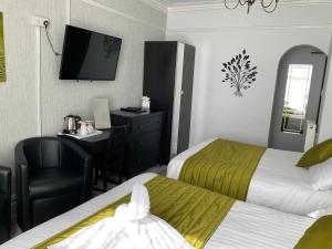 Pokój hotelowy z 2 łóżkami, biurkiem i telewizorem w obiekcie The Strathdon w Blackpool