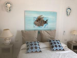 a bedroom with a bed with a painting on the wall at Luxury& Charme fronte mare Sardinia House7 in Carloforte