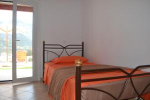 um quarto com uma cama com um cobertor laranja em Bali House em Balíon