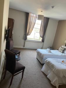 um quarto de hotel com duas camas e uma janela em The Lambton Arms em Durham