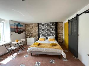 1 dormitorio con cama y pared de ladrillo en Les Chtis Bretons Chambres d hotes, en Trédion