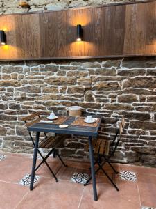 una mesa frente a una pared de piedra en Les Chtis Bretons Chambres d hotes, en Trédion