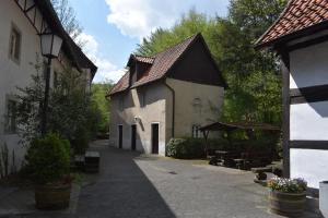 un callejón con un edificio, una mesa y árboles en Ferienwohnung Güse, en Detmold