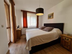 a bedroom with a bed and a window at Pirin Golf Apartment HOME with private garden in Bansko