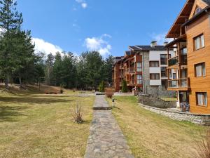 a stone path in front of a building at Pirin Golf Apartment HOME with private garden in Bansko