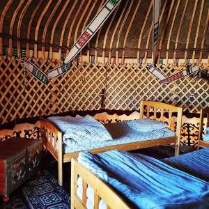 Kyzylkum Nights Camp & Family Yurt في Nurota: غرفة بسريرين في يورت