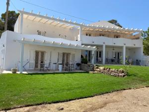 卡洛福泰的住宿－Luxury& Charme fronte mare Sardinia House7，前面有草坪的白色房子