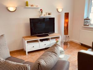 uma sala de estar com televisão e dois sofás em Wanderlust - Thüringer Wald, Rennsteig, Finsterbergen em Friedrichroda