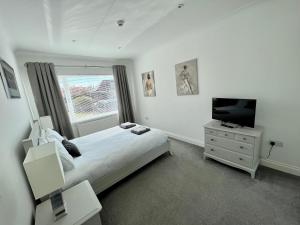 Dormitorio con cama y tocador con TV en Leworin, en Stirling