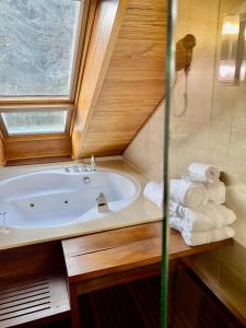 a bathroom with a tub and a window and towels at Hotel Riberies & SPA in Llavorsí