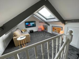 Zimmer im Dachgeschoss mit Sofa und TV in der Unterkunft Cheerful 2 Bedroom Townhouse with Cinema Loft in Pembrokeshire