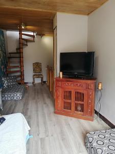 a living room with a television on a wooden cabinet at Entre Mer et Montagne Maison de village AVEC VUE SUR LE CANIGOU à 5 minutes à pied du Lac, située dans le joli village de Vinca, Village aux 3 lacs, SOLEIL et Campagne in Vinça
