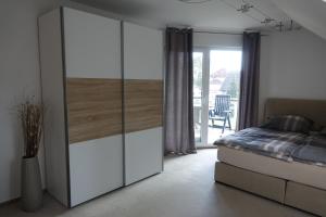 1 dormitorio con cama y armario blanco en Ferienwohnung Thuja en Wandlitz