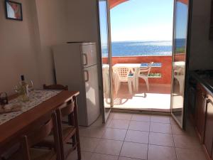 a kitchen with a refrigerator and a view of the ocean at belvedere acqua dolce 1 in Cala Gonone