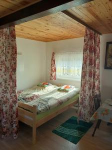 a small bedroom with a bed with a window at Wczasy na Kaszubach u Hani in Wiele