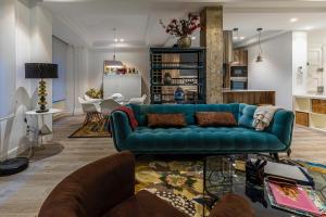 a living room with a blue couch and a kitchen at 110 M2 Central apartment in Abando Close To Guggenheim with parking in Bilbao
