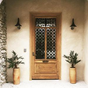 une porte en bois sur une maison avec deux plantes en pot dans l'établissement Le Patio - Vallée d'Aspe, à Bedous