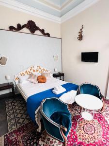 una camera con letto, tavolo e sedie di Sofia Katane Suites a Catania