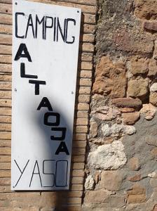 una señal en el costado de una pared de ladrillo en camping yaso-guara en Yaso