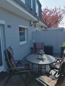 a patio with chairs and a table with a vase of flowers at Bude im Windrosenweg in Cuxhaven