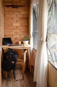 a room with a desk with a laptop and a bag at DugDug Camps - Glamping Amidst Nature in Bhīm Tāl