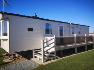 a white trailer with a ramp and a house at Caravan L25 in Mablethorpe