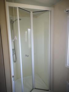 a shower stall with a glass door in a bathroom at Caravan L25 in Mablethorpe