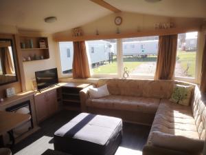 a living room with a couch and a large window at Caravan L25 in Mablethorpe