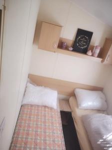 a small room with two beds and a book at Caravan L25 in Mablethorpe