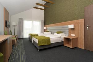 Łóżko lub łóżka w pokoju w obiekcie Kalinowe Pola Golf Village