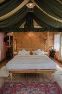 una camera con un grande letto in una tenda di DugDug Camps - Glamping Amidst Nature a Bhimtal