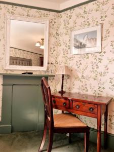 a desk in a room with a mirror and a chair at Villa Rothsay Hotel in Cowes