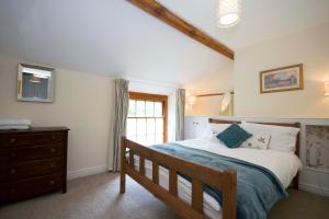um quarto com uma cama, uma cómoda e uma janela em Riverside Cottage em Llangollen