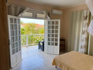 a bedroom with a door open to a balcony at Villa spacieuse avec piscine privée - Le Vauclin in Le Vauclin
