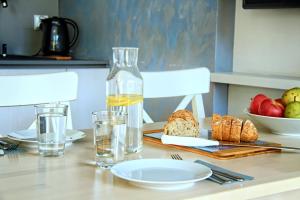 una mesa con pan y una botella de agua y vasos en Kwiatowa6 Apartamenty Szczawnica, en Szczawnica